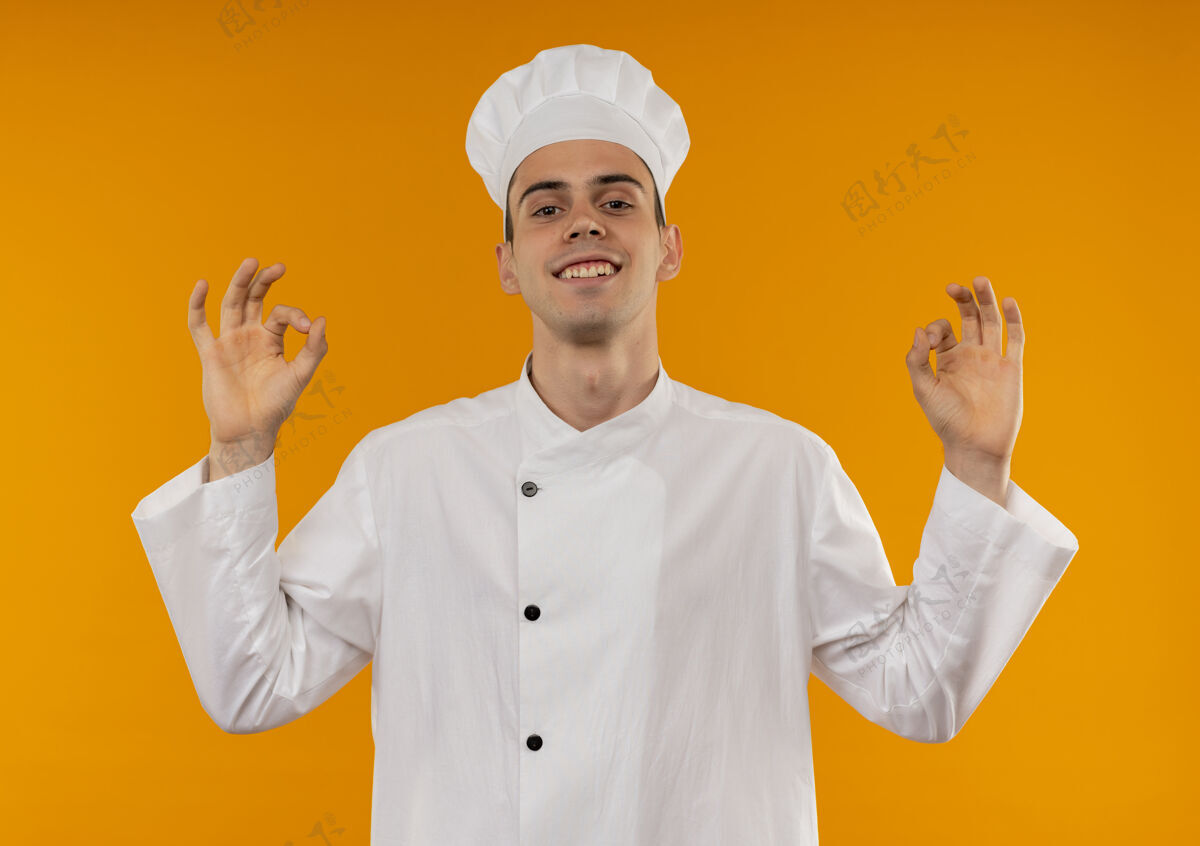 穿着微笑的年轻男性 穿着厨师制服 动作很好好的酷展示