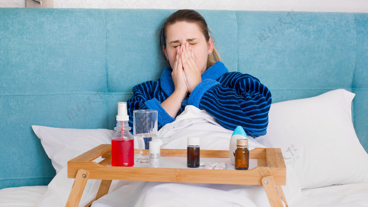 药物患感冒的年轻妇女躺在床上 手里拿着很多药和药丸健康病毒女性