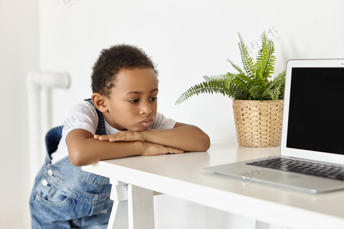 孩子人 童年 科技和现代电子产品电脑坐着无聊