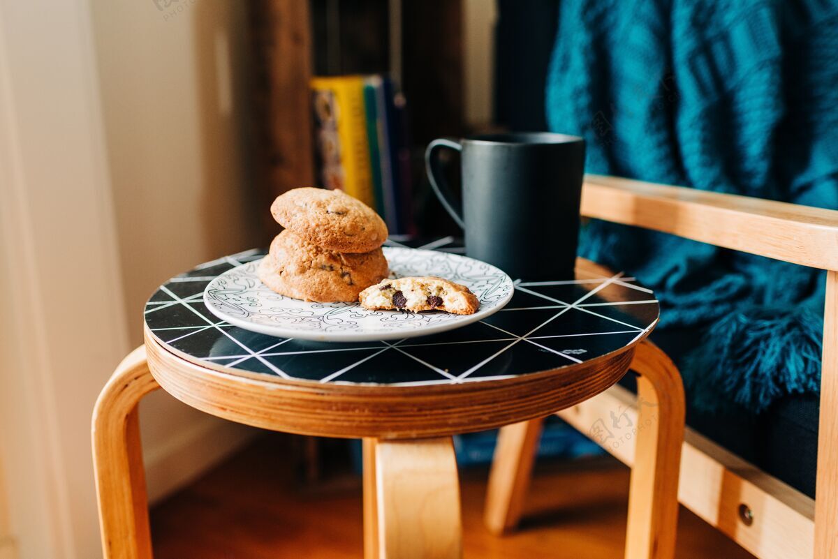 糖果在咖啡馆的黑桌子上 一盘美味的饼干放在一个黑咖啡杯旁边风味甜点木头