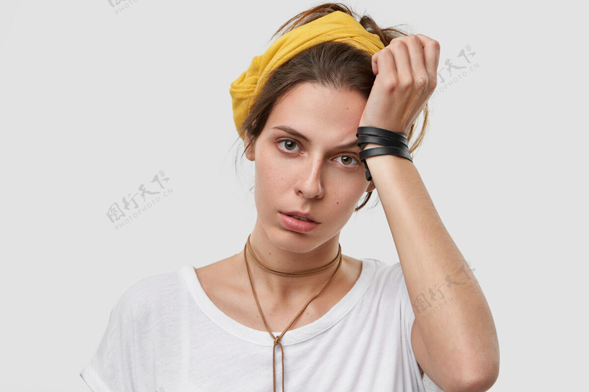 面部失意的年轻白种女人双手抱头 戴着黄色围巾 穿着白色休闲服 有疲惫的表情 加班 做家务配偶孤独疲倦