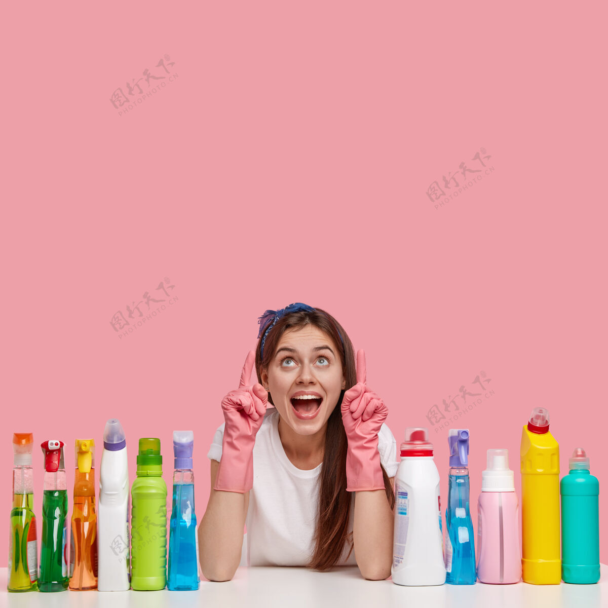 惊奇快乐主妇垂直镜头 正面惊呼 戴橡胶防护手套 为你的广告指向上洗涤剂卫生家务