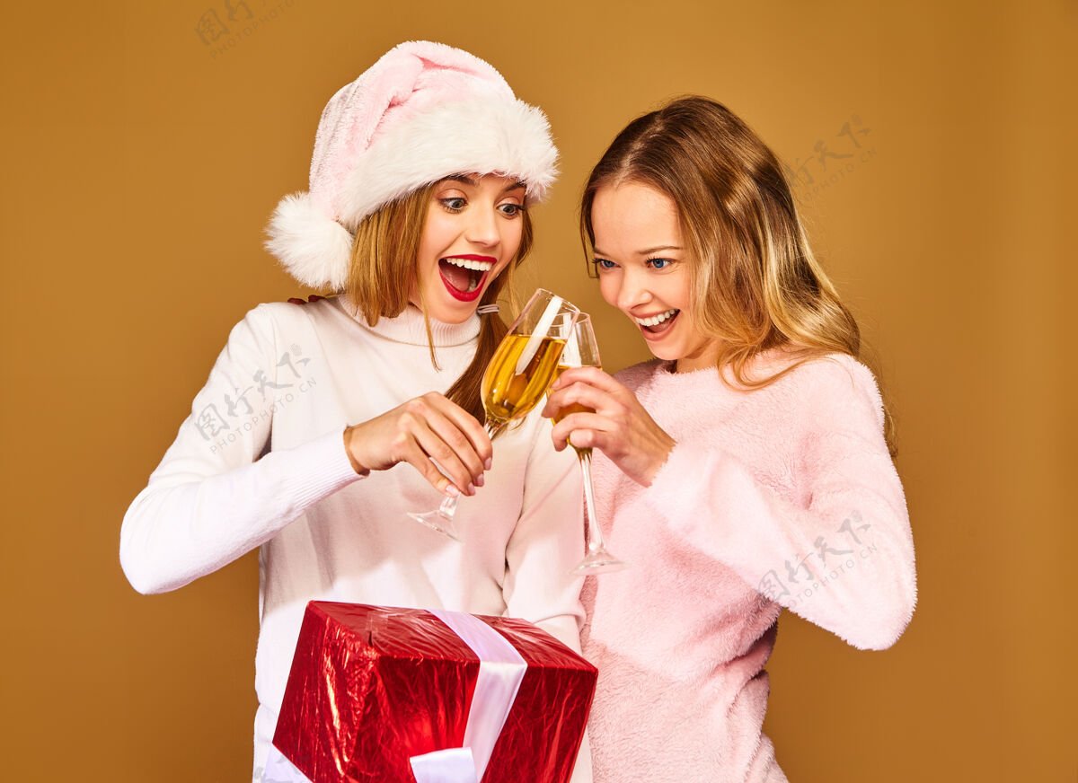 人们带着大礼盒的模特戴着酒杯喝香槟庆祝新年肖像圣诞老人圣诞老人